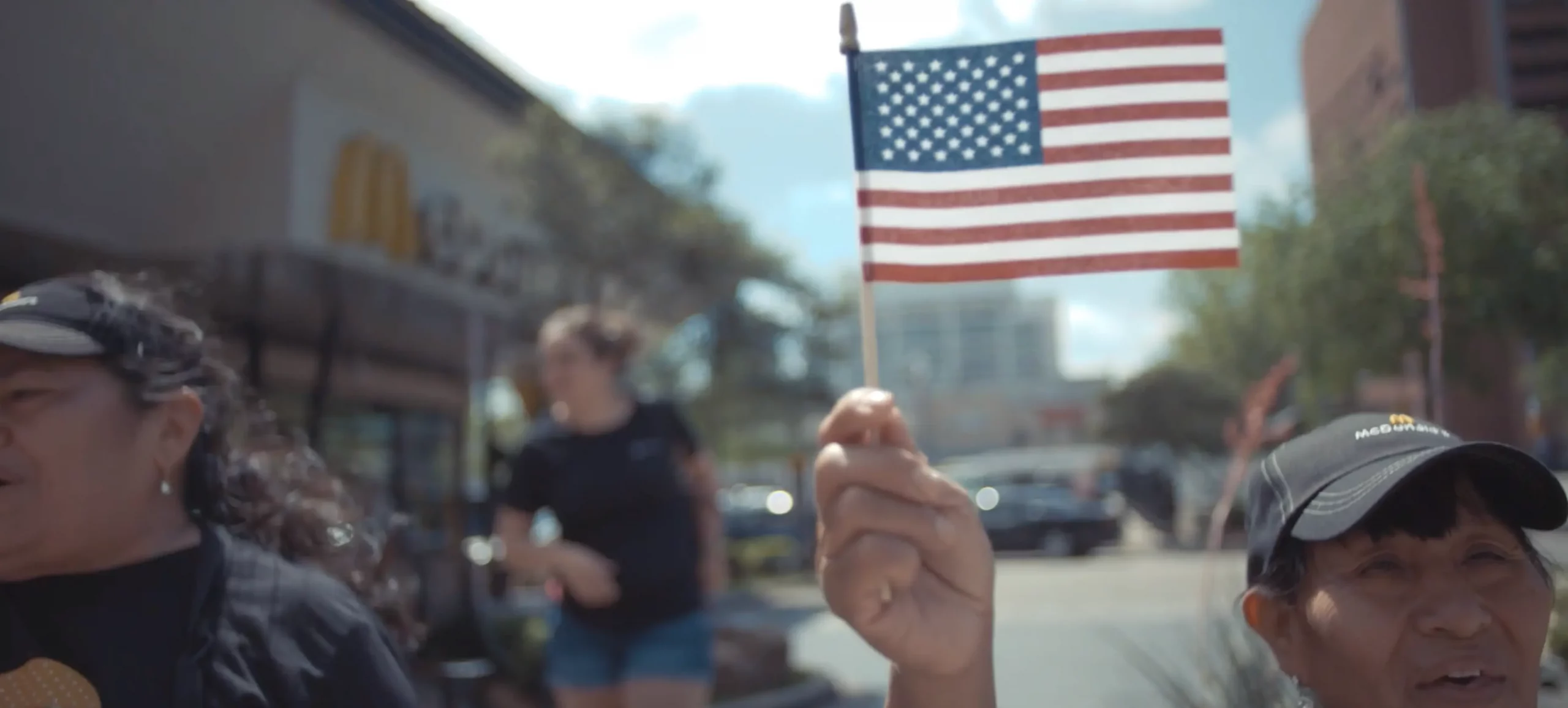 A person waving an American flag during a protest as part of a nonprofit advocacy video.