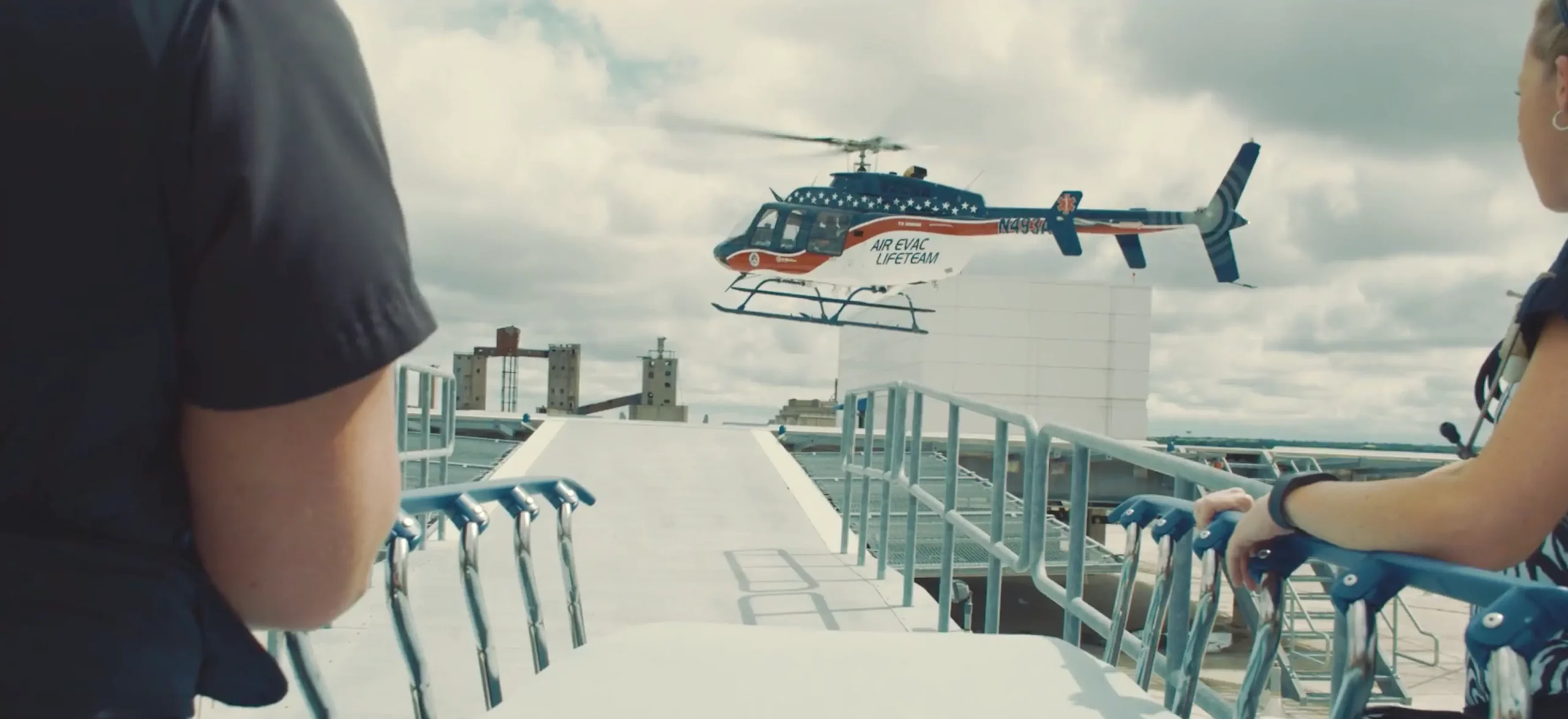 Behind the scenes of a medical video production set with a medical rescue helicopter landing on a barge.
